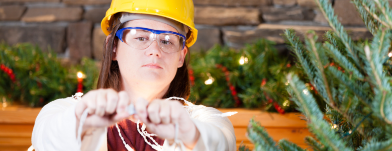 young woman adding lights to the christmas tree